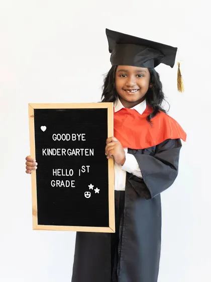 Holding the graduation board with pride. Capturing these school milestones is a wonderful way to document your child's growth and achievements over the years.