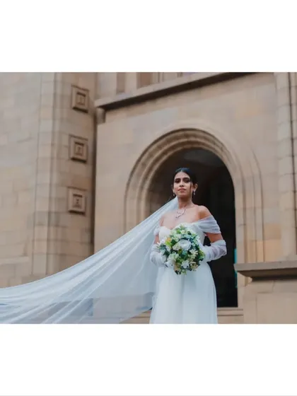 A stunning portrait of the bride, her veil flowing in the wind as she stands outside the church, a perfect blend of elegance and drama.