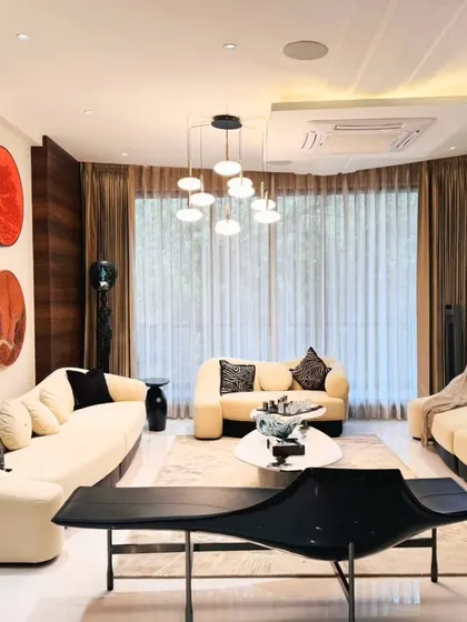 Another angle of the Paschim Vihar living room, highlighting the ample seating and natural light from the large windows. The design creates an atmosphere of effortless sophistication and comfort.