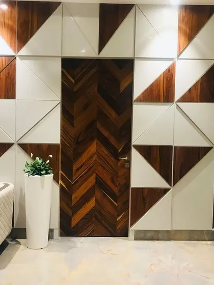 A unique feature wall I designed for an office in Faridabad. The geometric pattern, created using a mix of wood and white panels, conceals a door, blending it seamlessly into the wall for a clean and artistic look.