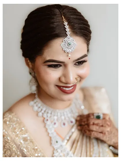 A happy bride with a radiant smile. The makeup highlights her features with a clean base, well-defined brows, and a beautiful lip color that ties the whole look together.