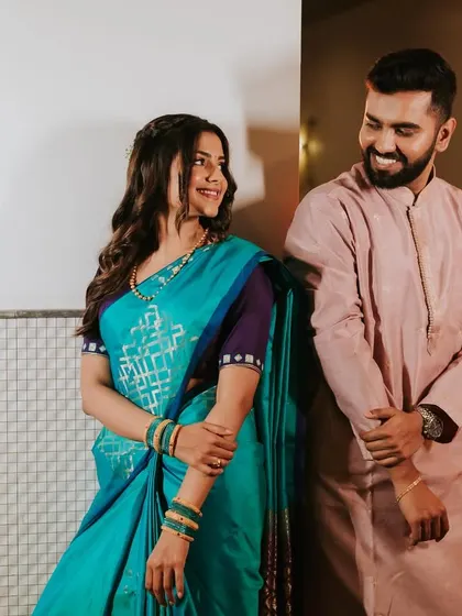 A playful and happy couple. The bride's makeup is natural and radiant, capturing their joyful interaction.