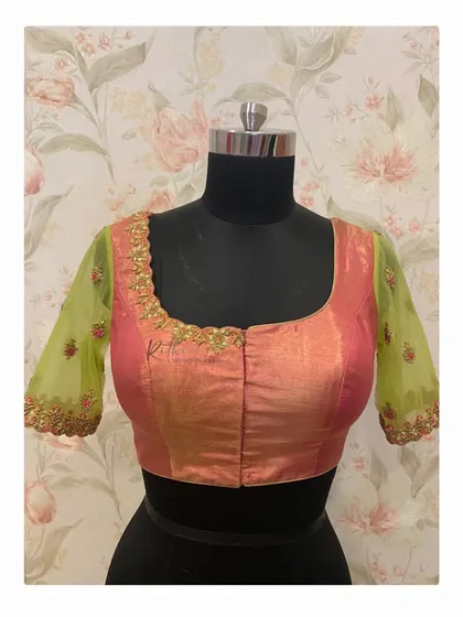 The front of the pink and green blouse, showing the simple pink silk body that balances the heavily embroidered sleeves.