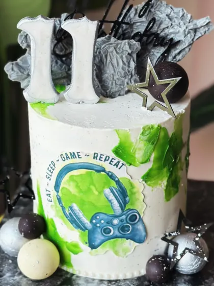 For the ones who find joy in every level. This modern gamer cake features an "Eat-Sleep-Game-Repeat" motif, a controller, and abstract textures for a gamer with taste.