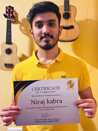 Niraj proudly holds his certificate for completing the Ukulele Intermediate Course. We celebrate every step of our students' progress.