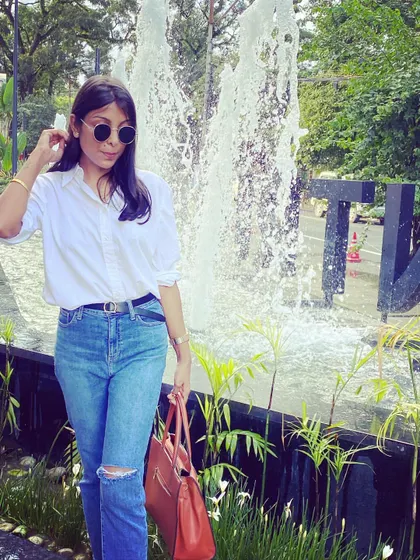 Being your own stylist means knowing how to put together simple, effective outfits like this one: a white shirt, ripped jeans, and a statement bag.