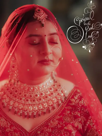 A close-up, artistic portrait of the bride with her eyes closed, her face illuminated by a soft red light from her veil.