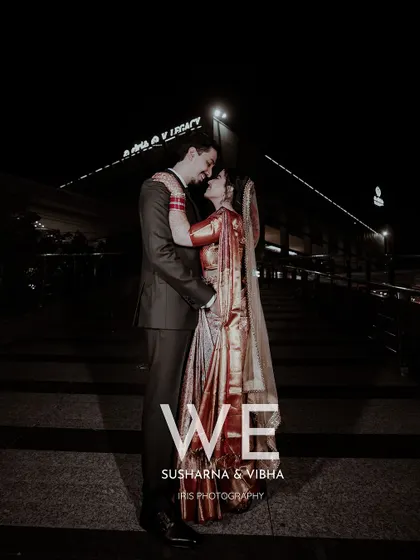 A dramatic night time portrait of the couple. The city lights in the background add a modern, urban feel to this romantic wedding photo.