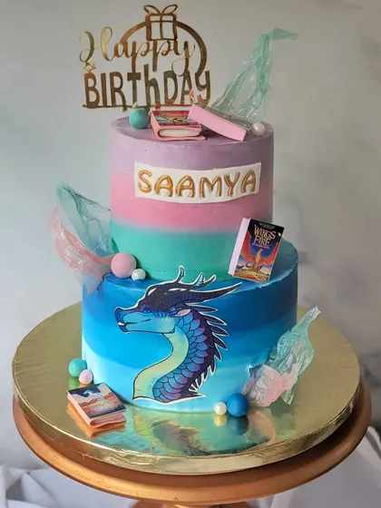 A cake for a "Wings of Fire" fan. This two-tier design features a dramatic dragon, rice paper sails, and mini edible books from the series.