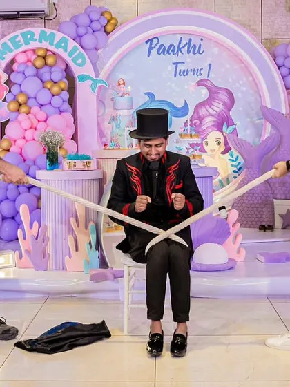 Entertainment at the mermaid party, featuring a magician performing a trick with the help of two guests.