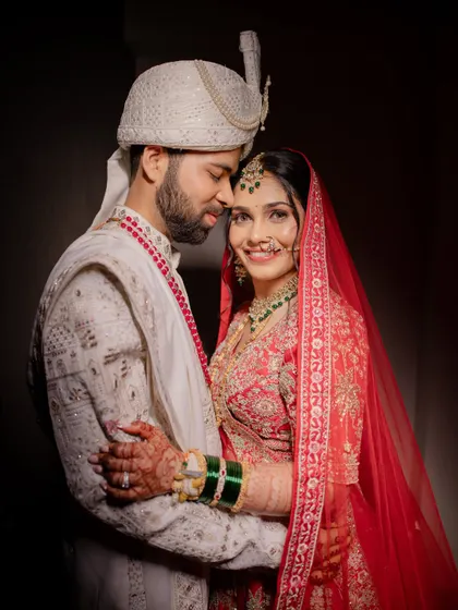 Creating a look that makes a bride feel confident and beautiful next to her partner is my ultimate goal. This portrait showcases a complete bridal lehenga look, with makeup that shines in professional lighting and complements the groom's attire perfectly.