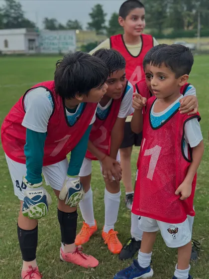 Even our youngest players are strategists. Here, a group of kids plan their approach right before a penalty shootout in a practice game.