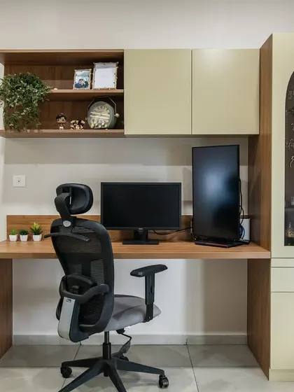 This study area features a custom-built unit with a wooden desk, overhead cabinets, and an arched glass-front display cabinet. The design provides a perfect balance of open and concealed storage for a functional workspace.