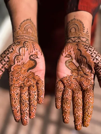 A stunning peacock design that covers the palm. The feathers are intricately detailed, creating a beautiful fan-like effect. This is a powerful and graceful design for any occasion.