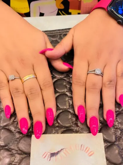 A bold and confident set of long, almond-shaped nails in a vibrant, glossy hot pink. This color is sure to make your hands the center of attention.