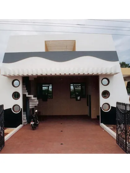 The entrance to the covered parking area at the CC Office (2002). The design incorporates the building's signature tapered form and circular window details, ensuring even functional spaces adhere to the project's unique architectural language.