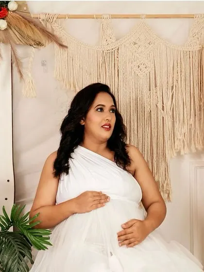 A thoughtful, candid-style portrait of the mom-to-be, looking off into the distance as she cradles her bump.