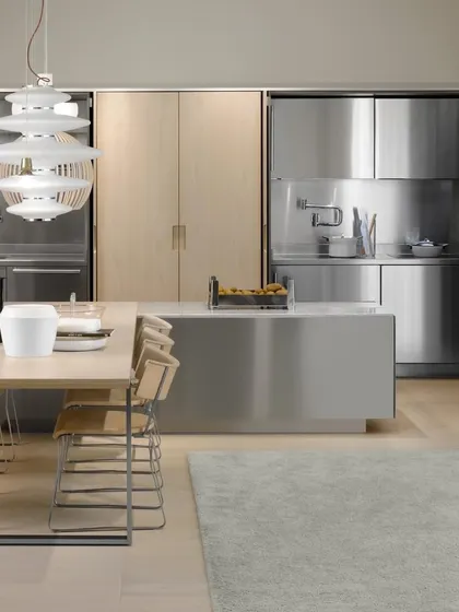 This kitchen showcases the sleek, professional look of stainless steel paired with light wood. It is a perfect example of how I use premium metals to create a durable and modern culinary workspace.