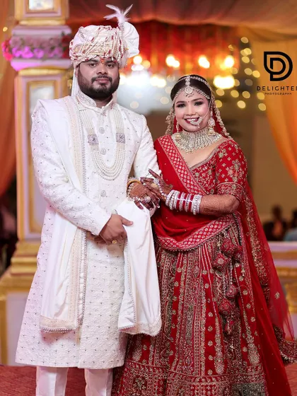 A classic stage portrait of the bride and groom on their wedding day. They look regal and happy in their beautiful traditional attire.