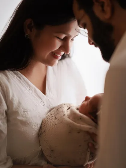 A mother gazing at her precious baby. This intimate, softly lit moment from a home session perfectly captures the beginning of their beautiful bond.