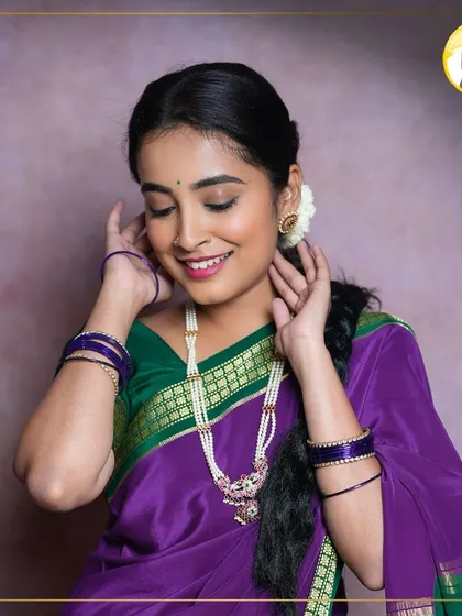 A candid shot showing the details of this traditional look. The makeup is soft and feminine, with a gentle smile and glowing skin, complemented by the jasmine flowers in the hair.