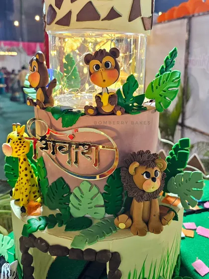 A close-up of one of the jungle cakes, featuring a clear tier filled with fairy lights for a magical effect.