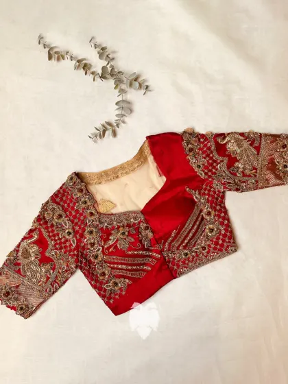 Priya’s maroon raw silk masterpiece, where the sheer net back showcases a vibrant wedding procession with a majestic elephant motif.