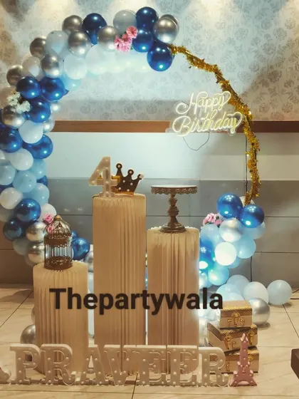 A simple and elegant ring decoration with blue, white, and silver balloons. The single pedestal and light-up number "4" create a clean and focused look.