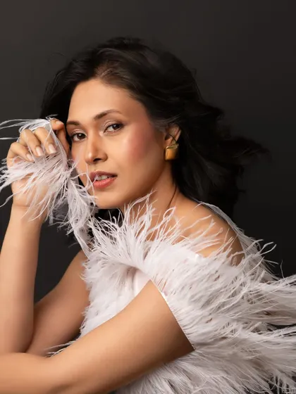 This portrait from a giveaway session is all about ethereal beauty. The white feathers add a soft, dreamlike quality, and her direct gaze is simply captivating.