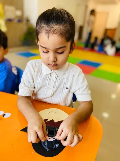 This little girl is carefully assembling her craft, showing her intense focus and developing dexterity.