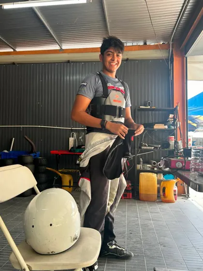 A driver takes a break between sessions during his international debut at the RMC Asia Trophy, smiling after a strong performance.