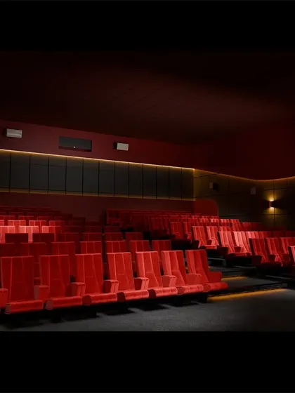An empty view of the red-seated theater, highlighting the clean, functional design and the strategic placement of speakers and lighting.