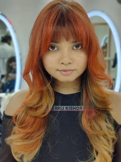 A full-on view of this 2000s-inspired hair color. The bright orange roots and blonde ends are fun, creative, and totally unique.