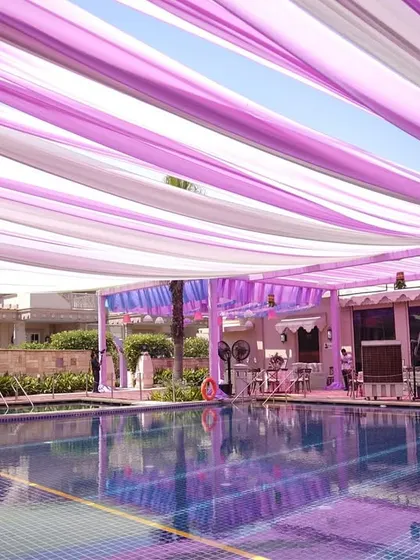 The daytime view of the pastel canopy over the pool. The light filtering through the lilac and white drapes created a serene and beautiful ambiance.