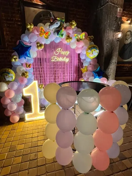 The unicorn birthday setup placed in a restaurant with rustic brick walls, showing how my decorations can fit into any venue.