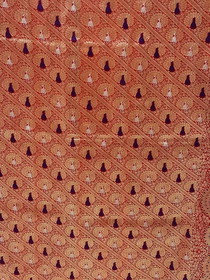 A close-up of a luxurious Banarasi fabric, showcasing a "Shades of Royalty" color palette of merlot, sangria, and burnt orange.