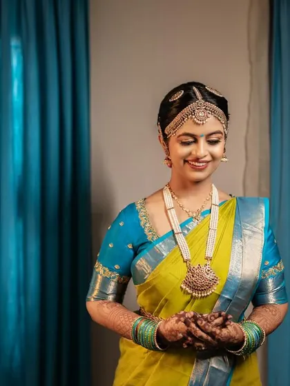 The final look, perfectly complemented by the vibrant colors of her saree and the traditional temple jewelry. The airbrush finish ensures she looks flawless from every angle.