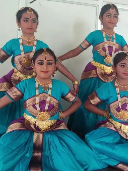 My young Bharatanatyam dancers striking a classic pose during their Onam celebration performance. They learn not just the steps, but also the discipline and grace that comes with classical dance.