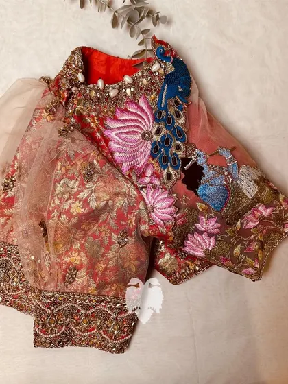 Another view of the red brocade blouse, showcasing the unique union of brocade and net fabrics to celebrate a love story.