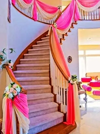 Simple and elegant home decor for a religious function or a small gathering. Using soft pink and cream drapes on a staircase can transform a home space and give it a serene, celebratory feel.