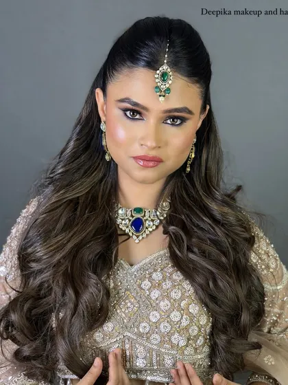 A powerful and confident pose from the bride in her silver lehenga. The bold, defined eyes and contoured cheeks give her a striking look.