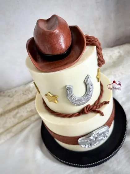 A 75th birthday cake for a jolly rancher with a passion for old Western movies, complete with a cowboy hat, horseshoe, and belt buckle.