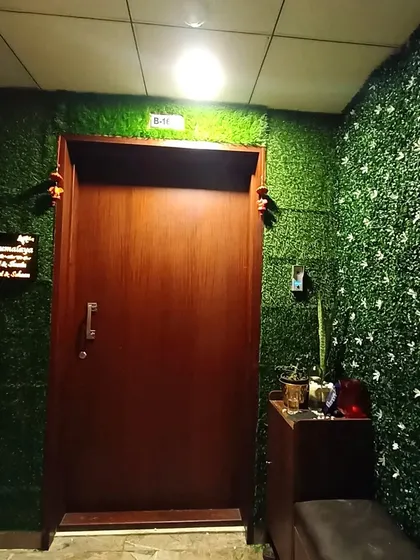 A full view of the apartment entrance makeover. The artificial grass walls surround the main door, making the entryway feel cozy and distinct from the rest of the building.