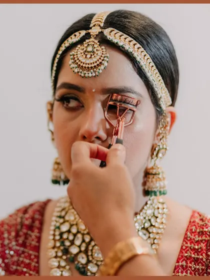 A candid shot of the bride getting her eyelashes curled. I capture these small, behind-the-scenes moments that build the story of the wedding day.