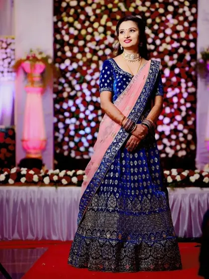 This royal blue velvet lehenga with intricate silver embroidery is a showstopper. Paired with a contrasting pink dupatta, it's a beautiful rental choice for a wedding reception or sangeet.