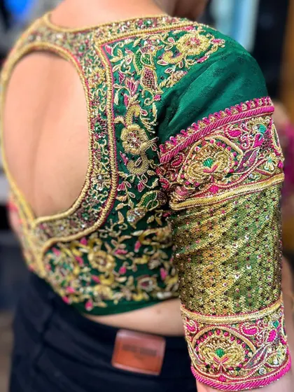 A unique sleeve design combining traditional zardosi work with modern sequin panels. The contrast in textures on this green blouse sleeve makes it a true statement piece.