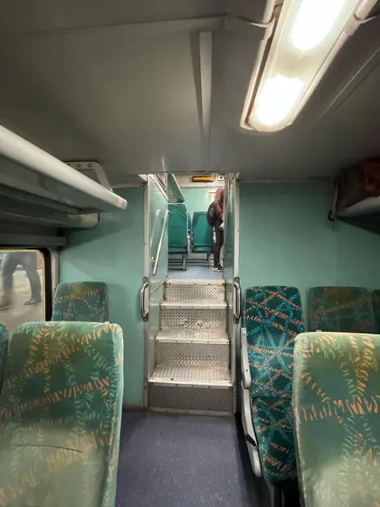 The stairway connecting the lower and upper levels of the double-decker coach, a rare sight in Indian railways.