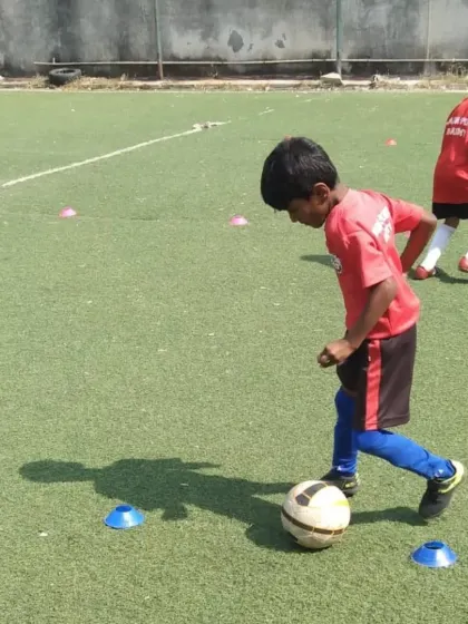 A young player focuses on a cone drill, building fundamental skills in a fun and supportive environment.