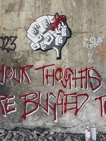 The second part of the Moodgrass piece, with the text "Your Thoughts Are Bugged Too" sprayed in red next to the original brain artwork. A witty and thought-provoking message.