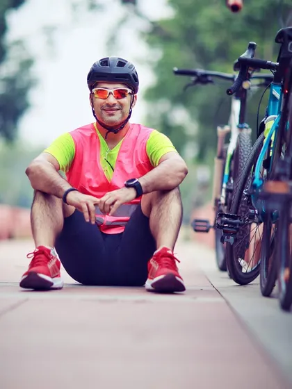 A member in a high-visibility vest, sitting with his bike. Safety is a top priority on all our rides.